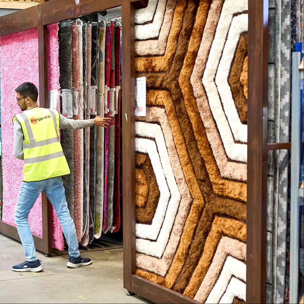 Person in a warehouse setting with wooden panel samples and furniture.